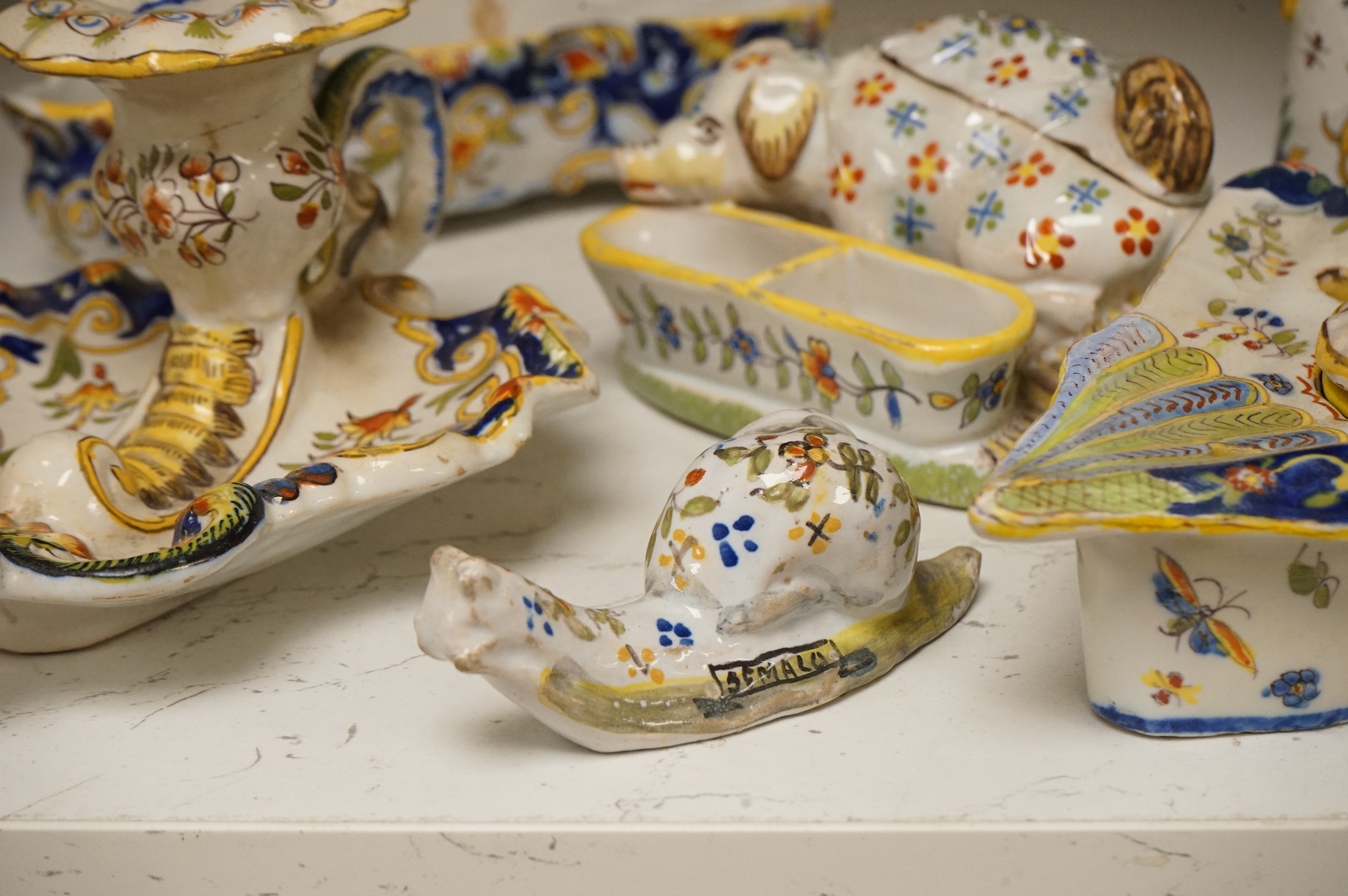 A group of French faience pottery to include spill vases, an ink well and dishes, largest 21cm high